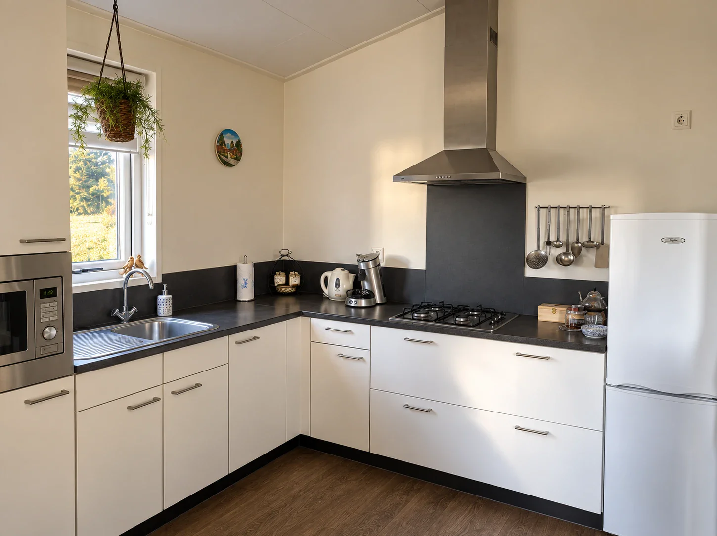 Volledig ingerichte witte hoekkeuken met gaskookplaat, afzuigkap, magnetronoven, Senseo, waterkoker en koel-vriescombinatie