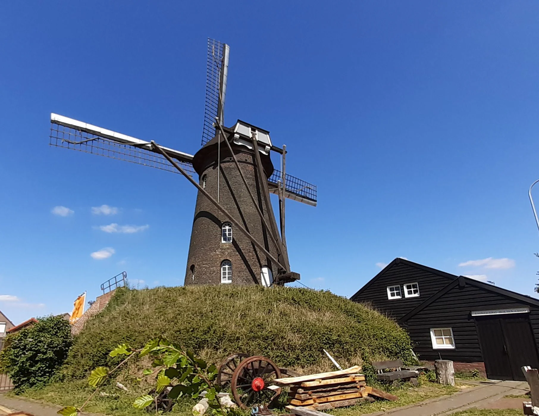 Stenen molen op een molenbelt in Deurne tegen een blauwe lucht